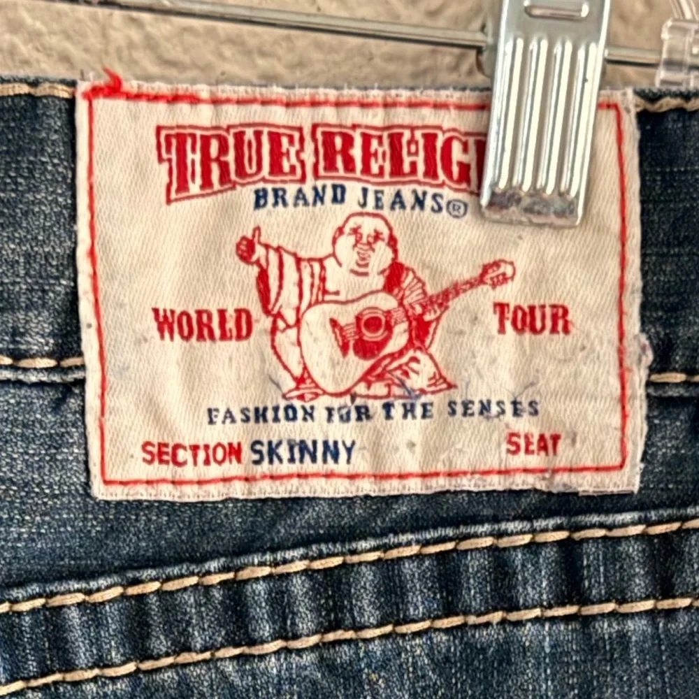 True Religion jeans feature a dark wash and bold signature stitching. Skinny